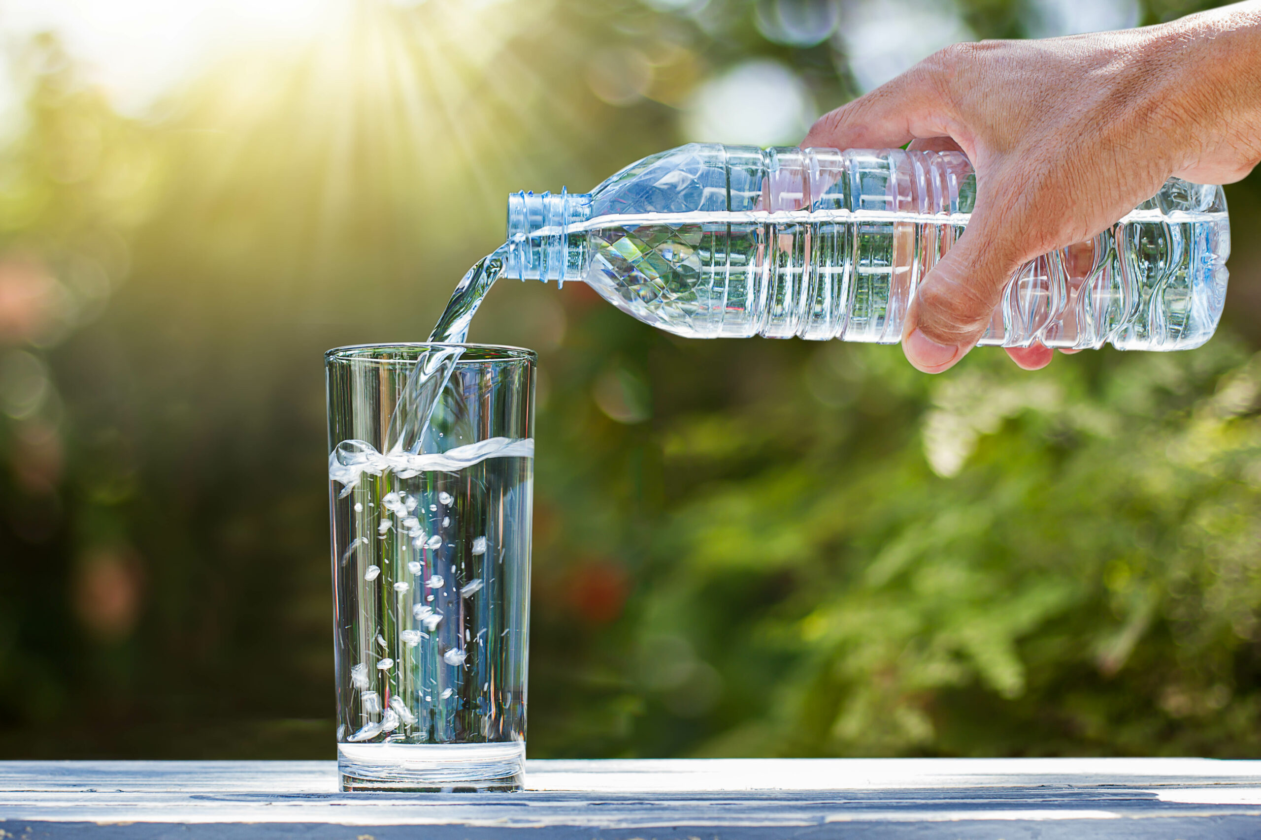 Pouring clean water into a glass from a water bottle